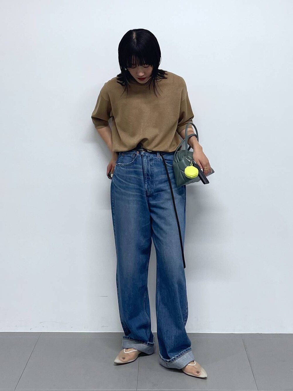 ベージュ系のTシャツ/カットソー、グリーン系のショルダーバッグ、ブルー系のデニムパンツを着用したレディースの夏コーディネートの2枚目の写真