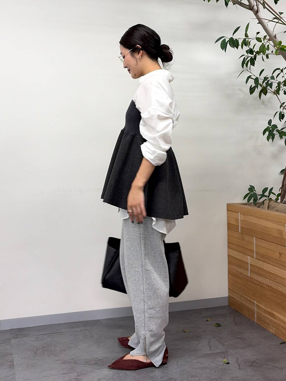 レッド系のパンプス、グレー系のスウェットパンツ、ブラック系のボストンバッグを着用したレディースの秋コーディネートの3枚目の写真