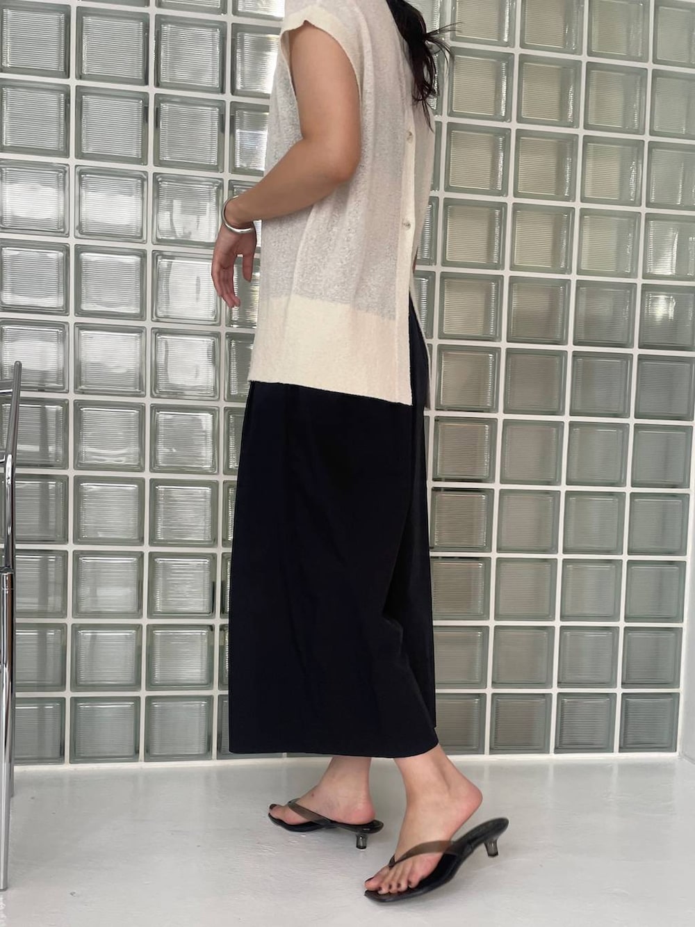 ブラック系のハンドバッグ、ブラック系のその他パンツ、ホワイト系のニット/セーターを着用したレディースの夏コーディネートの4枚目の写真