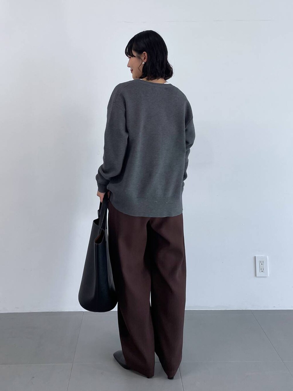 ブラック系のトートバッグ、ブラウン系のその他パンツ、グレー系のカーディガン/ボレロを着用したレディースの冬コーディネートの5枚目の写真