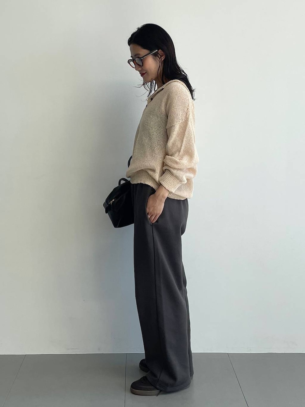 ブラウン系のスニーカー、ピンク系のニット/セーター、グレー系のスウェットパンツを着用したレディースの春コーディネートの4枚目の写真