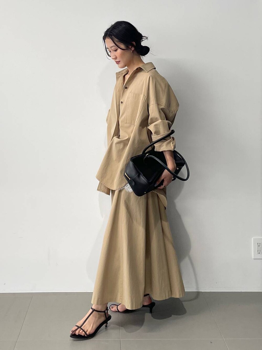 ブラック系のサンダル、ベージュ系のスカート、ベージュ系のシャツ/ブラウスを着用したレディースの春コーディネートの4枚目の写真