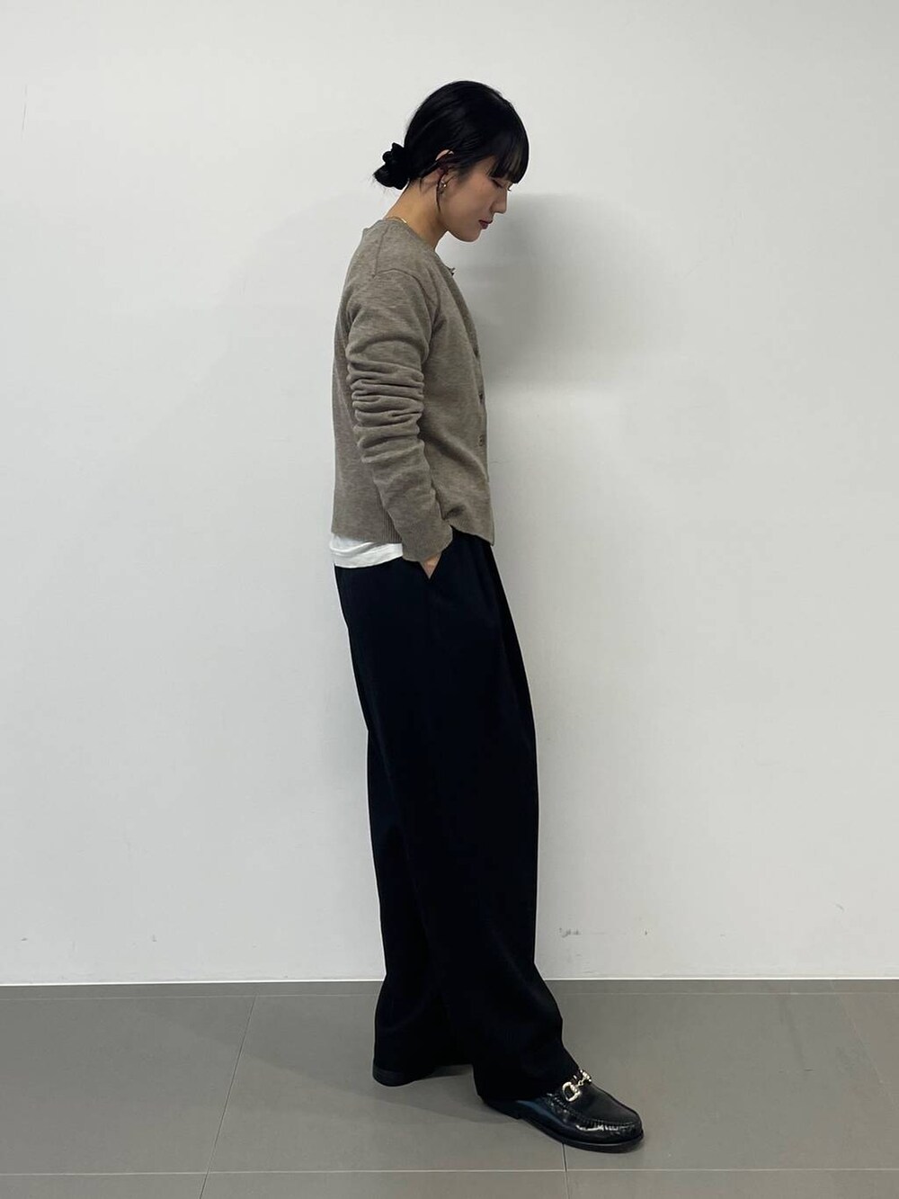 ホワイト系のハンドバッグ、ブラック系のその他パンツ、グリーン系のニット/セーターを着用したレディースの秋コーディネートの4枚目の写真