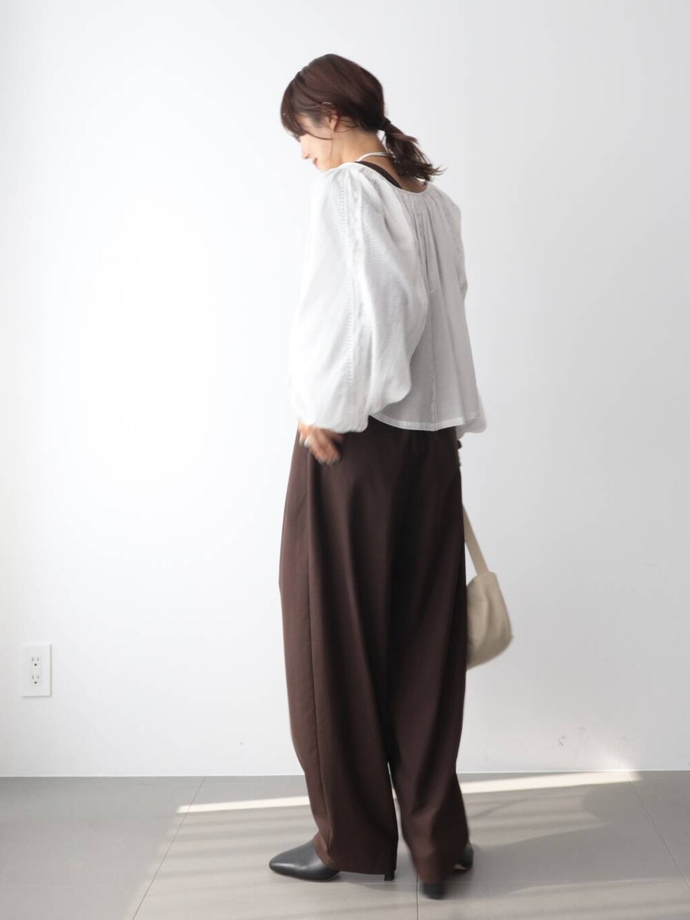 ホワイト系のシャツ/ブラウス、ブラウン系のその他パンツ、ホワイト系のショルダーバッグを着用したレディースの秋コーディネートの3枚目の写真