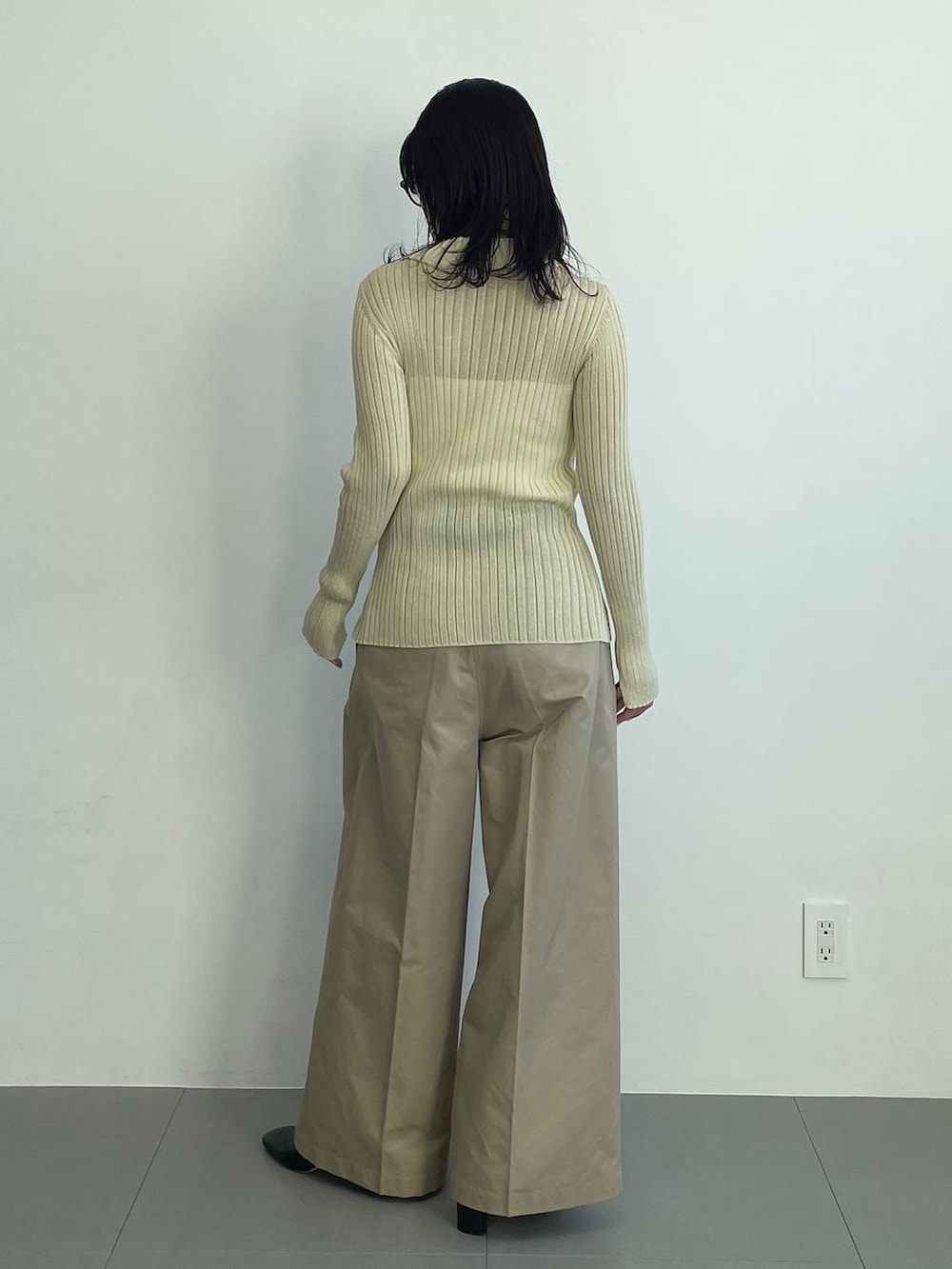 ブラック系のブーツ、ベージュ系のチノパンツ、イエロー系のニット/セーターを着用したレディースの冬コーディネートの5枚目の写真