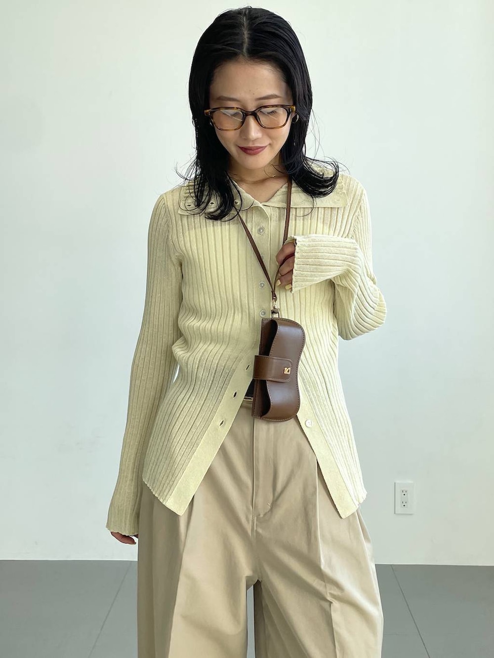 ブラック系のブーツ、ベージュ系のチノパンツ、イエロー系のニット/セーターを着用したレディースの冬コーディネートの6枚目の写真