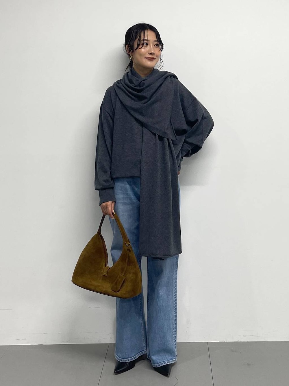 ブラック系のブーツ、ブラウン系のハンドバッグ、グレー系のニット/セーターを着用したレディースの冬コーディネートの3枚目の写真