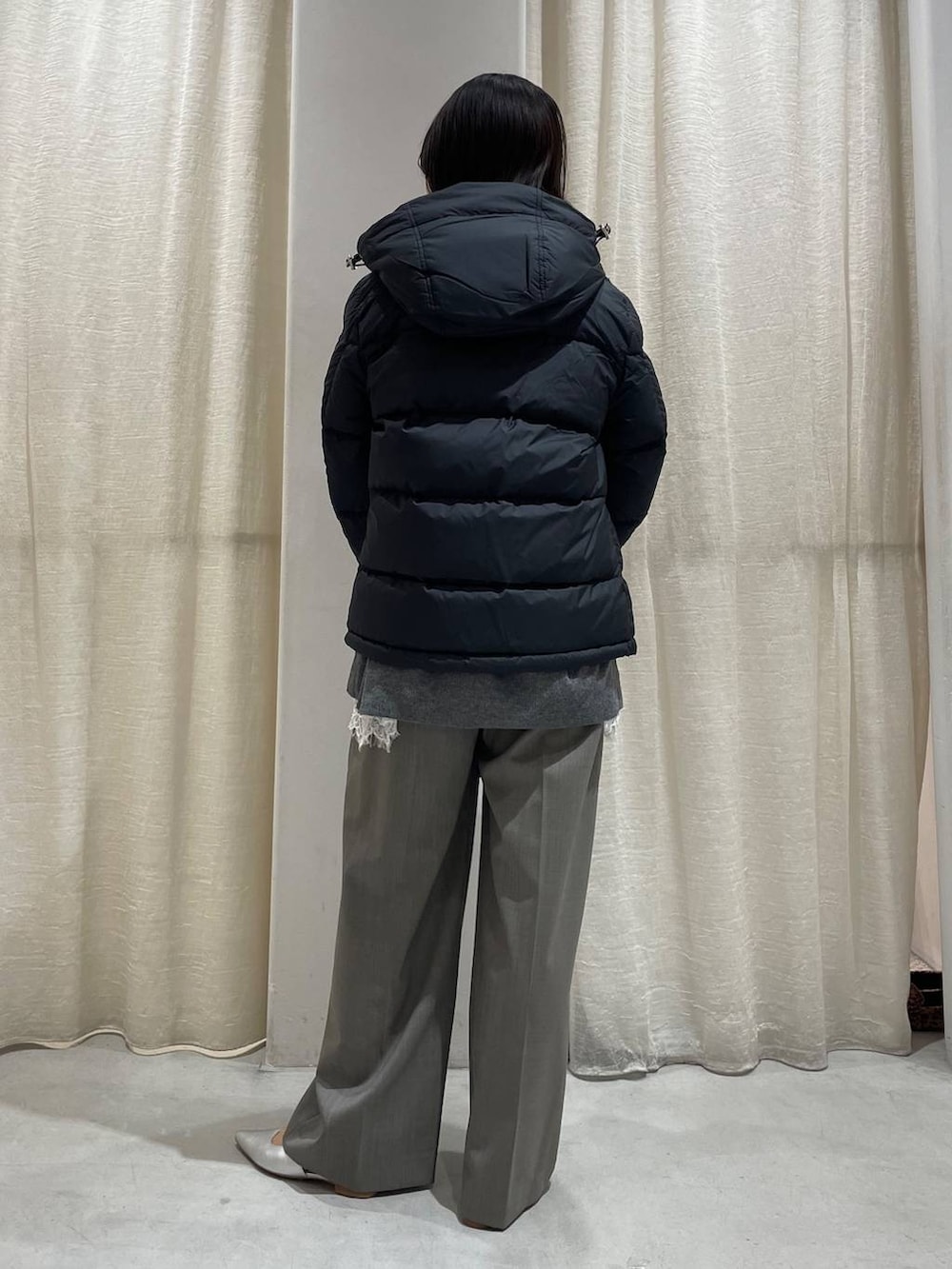 グレー系のスラックス、グレー系のニット/セーター、ホワイト系のキャミソールを着用したレディースの秋コーディネートの4枚目の写真