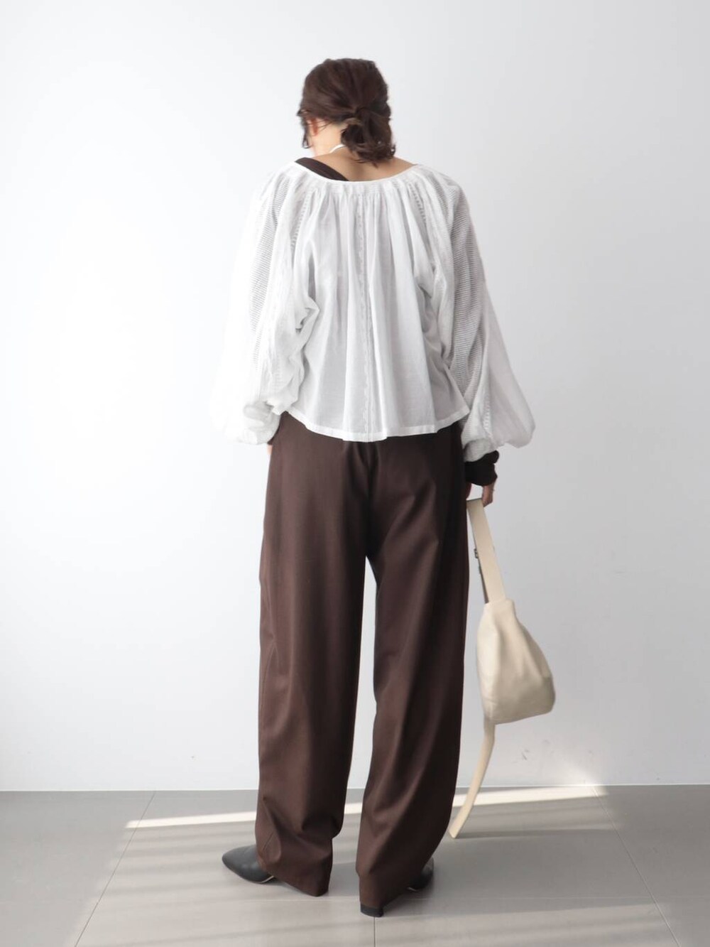 ホワイト系のシャツ/ブラウス、ブラウン系のその他パンツ、ホワイト系のショルダーバッグを着用したレディースの秋コーディネートの4枚目の写真