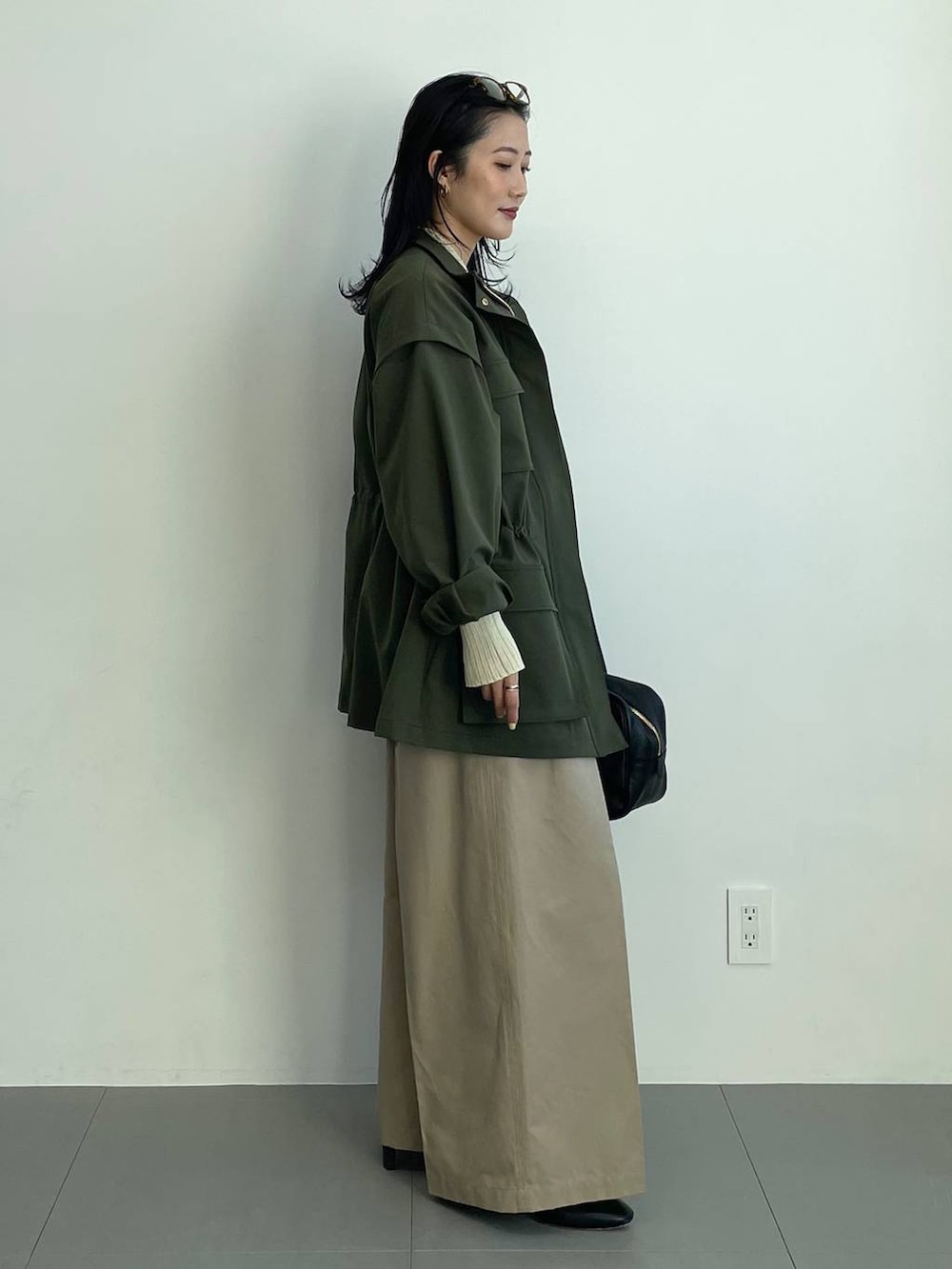 ブラック系のブーツ、ベージュ系のチノパンツ、イエロー系のニット/セーターを着用したレディースの冬コーディネートの4枚目の写真