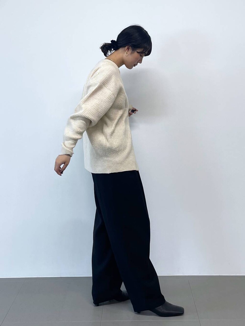 ブラック系のキャミソール、ブラック系のその他パンツ、ホワイト系のカーディガン/ボレロを着用したレディースの冬コーディネートの3枚目の写真