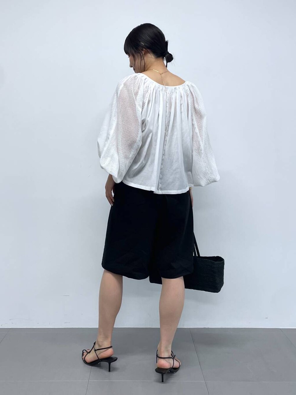 ブラック系のかごバッグ、ホワイト系のシャツ/ブラウス、ブラック系のサンダルを着用したレディースの夏コーディネートの3枚目の写真
