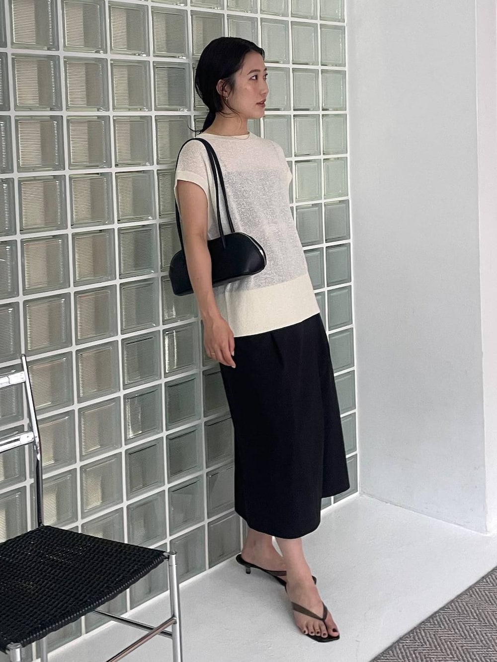 ブラック系のハンドバッグ、ブラック系のその他パンツ、ホワイト系のニット/セーターを着用したレディースの夏コーディネートの2枚目の写真