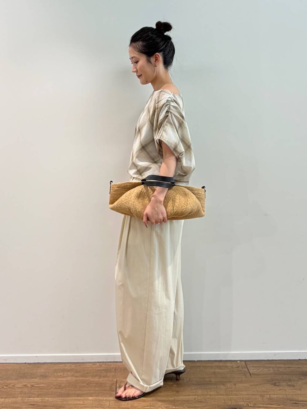 ベージュ系のシャツ/ブラウス、ベージュ系のかごバッグ、ブラウン系のサンダルを着用したレディースの夏コーディネートの2枚目の写真
