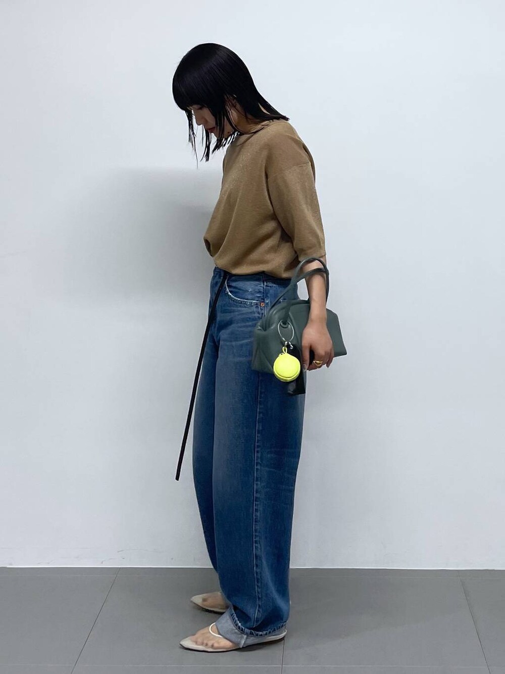 ベージュ系のTシャツ/カットソー、グリーン系のショルダーバッグ、ブルー系のデニムパンツを着用したレディースの夏コーディネートの3枚目の写真