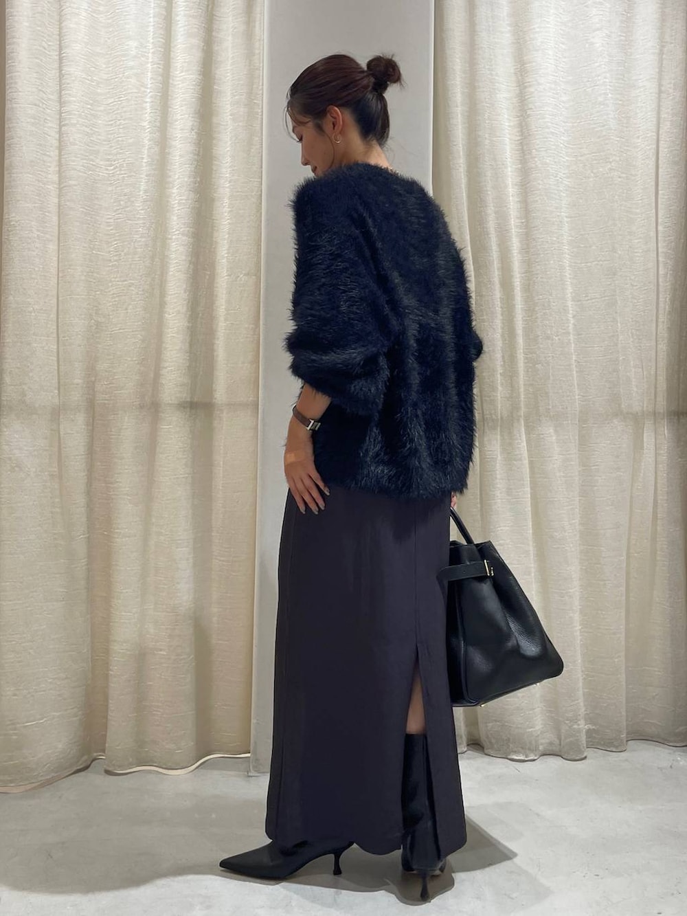 ブラック系のカーディガン/ボレロ、グレー系のスカート、ブラック系のハンドバッグを着用したレディースの秋コーディネートの5枚目の写真