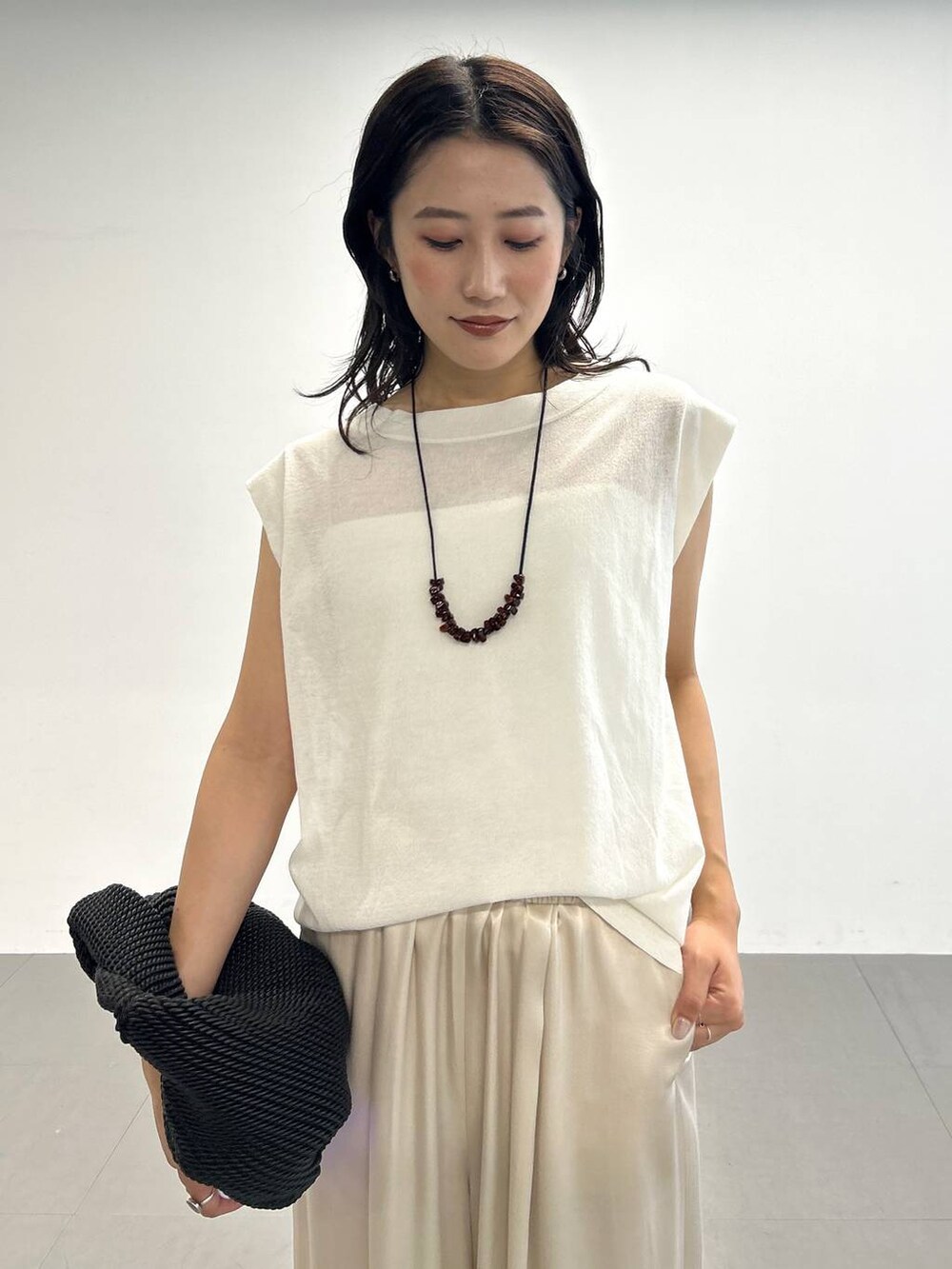 ベージュ系のその他パンツ、ホワイト系のTシャツ/カットソー、ブラック系のサンダルを着用したレディースの夏コーディネートの6枚目の写真