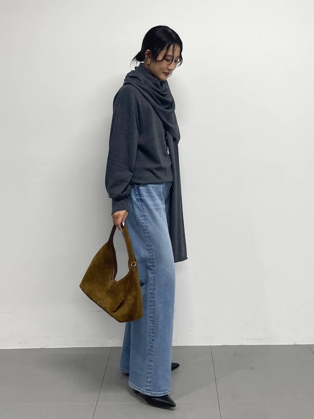 ブラック系のブーツ、ブラウン系のハンドバッグ、グレー系のニット/セーターを着用したレディースの冬コーディネートの5枚目の写真