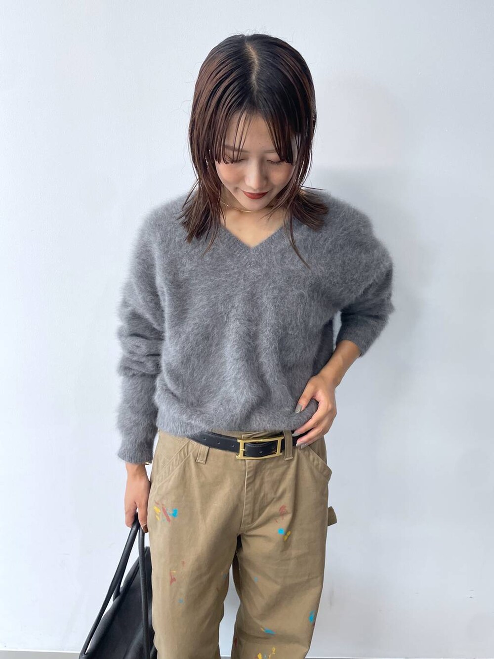 グレー系のニット/セーター、ブラック系のボストンバッグ、ブラック系のブーツを着用したレディースの秋コーディネートの5枚目の写真