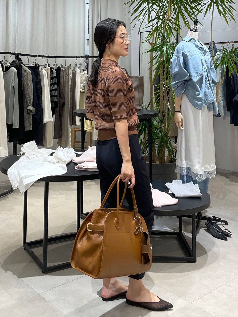 ブラック系のパンプス、ブラウン系のボストンバッグ、ブラック系のその他パンツを着用したレディースの春コーディネートの3枚目の写真