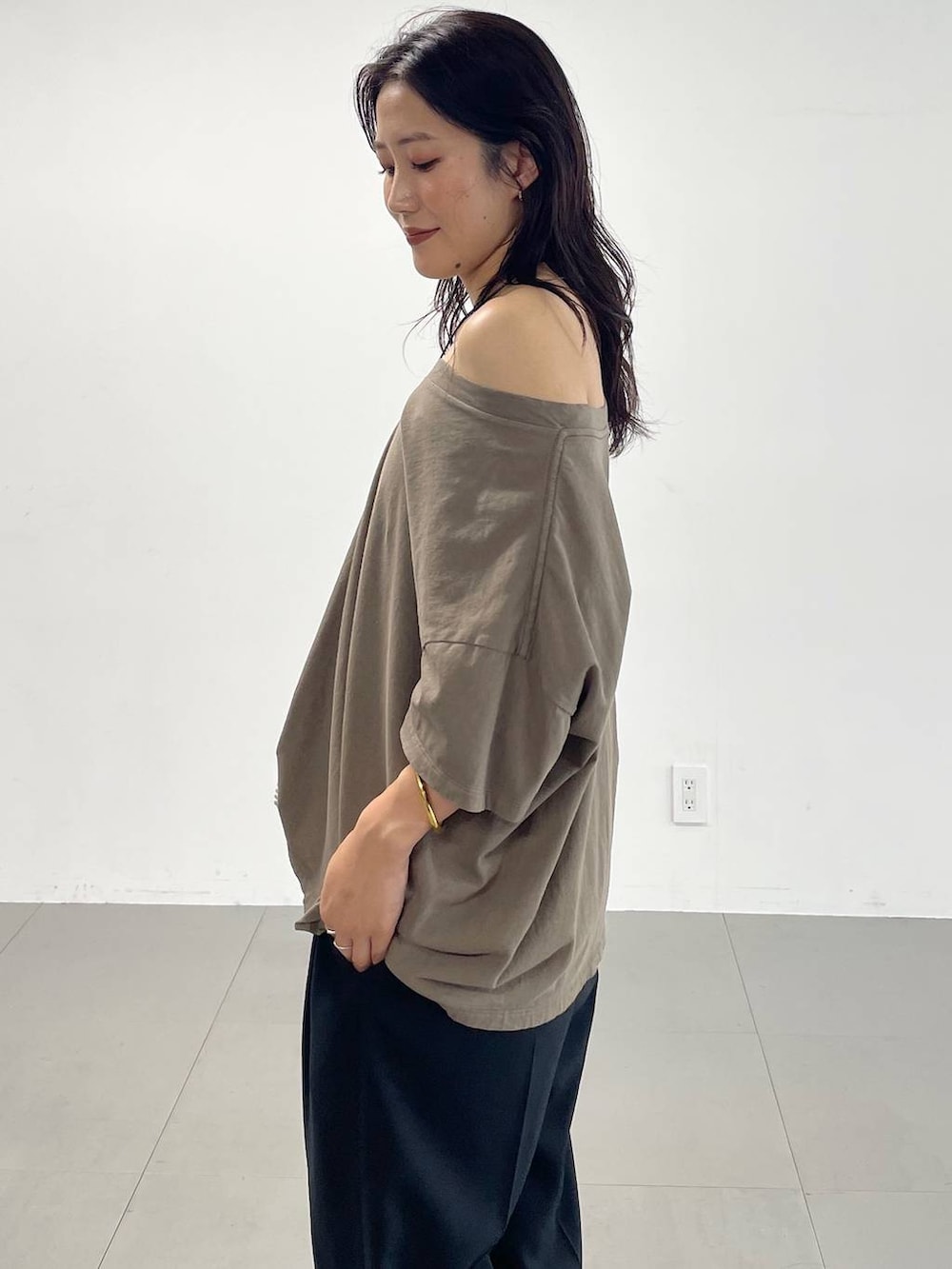 ブラック系のスラックス、グリーン系のTシャツ/カットソー、ブラック系のサンダルを着用したレディースの夏コーディネートの6枚目の写真
