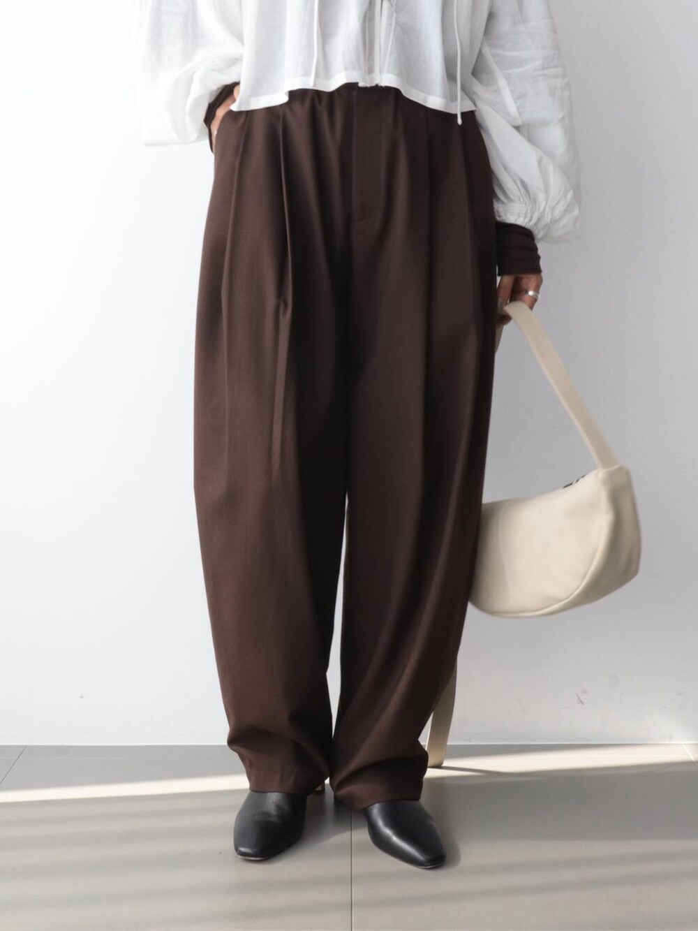 ホワイト系のシャツ/ブラウス、ブラウン系のその他パンツ、ホワイト系のショルダーバッグを着用したレディースの秋コーディネートの5枚目の写真