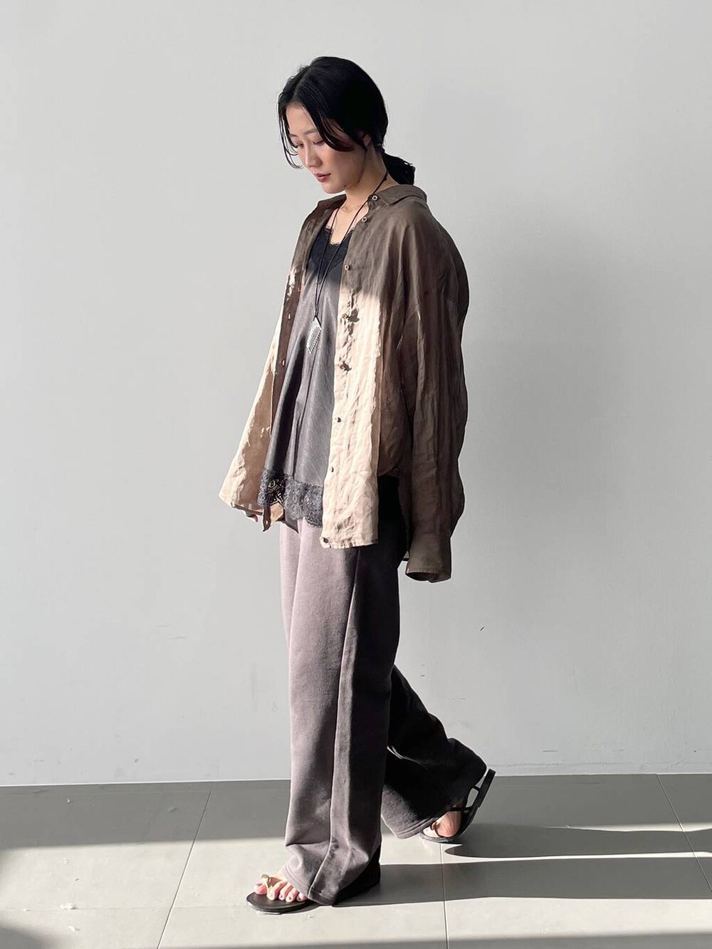 グリーン系のシャツ/ブラウス、ブラック系のキャミソール、グレー系のスウェットパンツを着用したレディースの春コーディネートの4枚目の写真