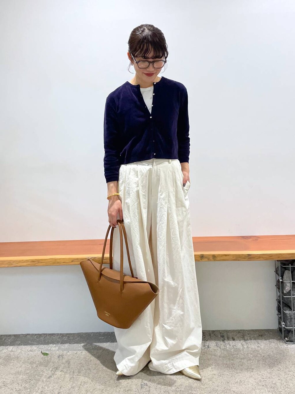 イエロー系のハンドバッグ、ホワイト系のタンクトップ、ホワイト系のその他パンツを着用したレディースの春コーディネートの2枚目の写真