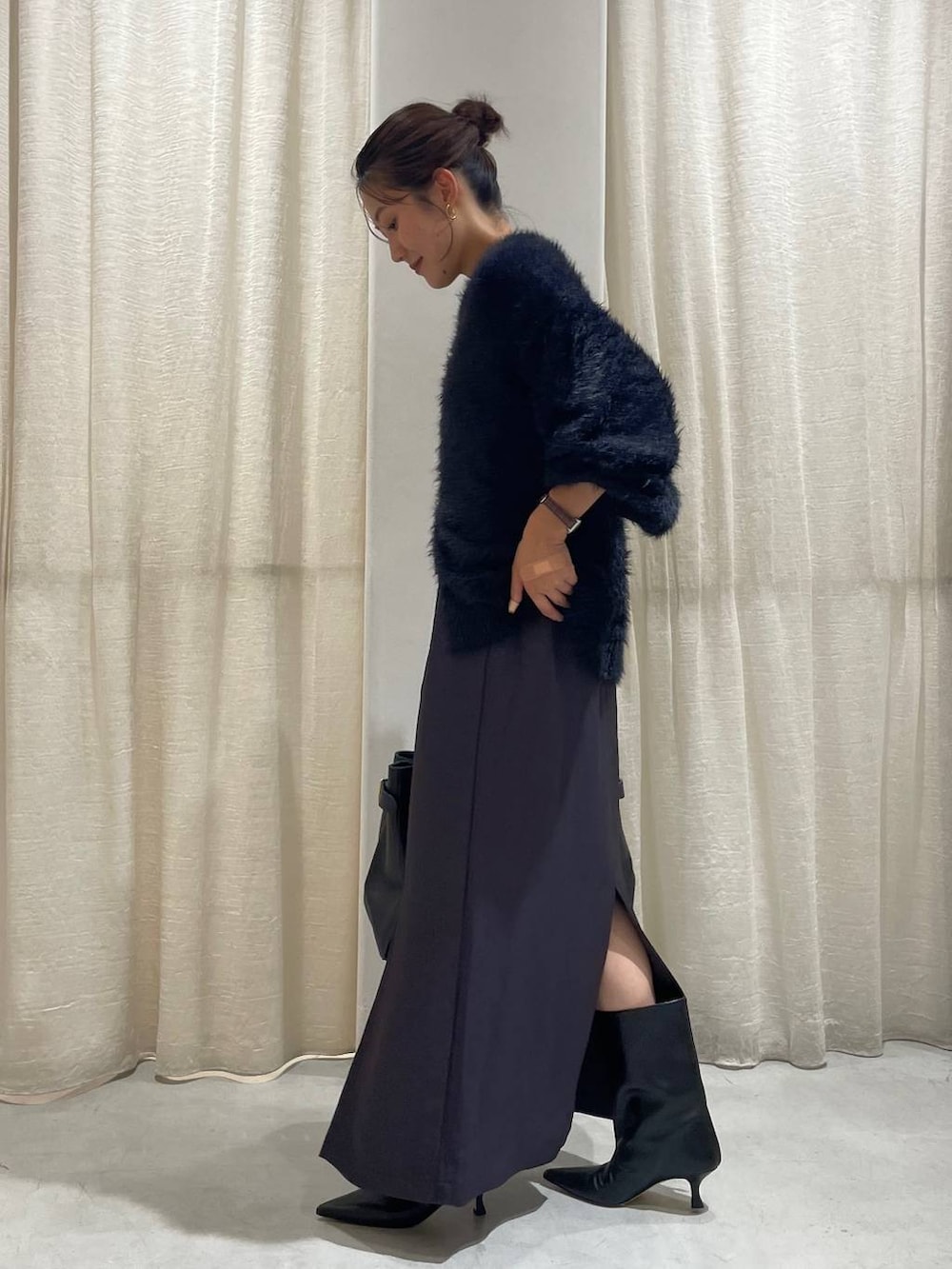 ブラック系のカーディガン/ボレロ、グレー系のスカート、ブラック系のハンドバッグを着用したレディースの秋コーディネートの3枚目の写真