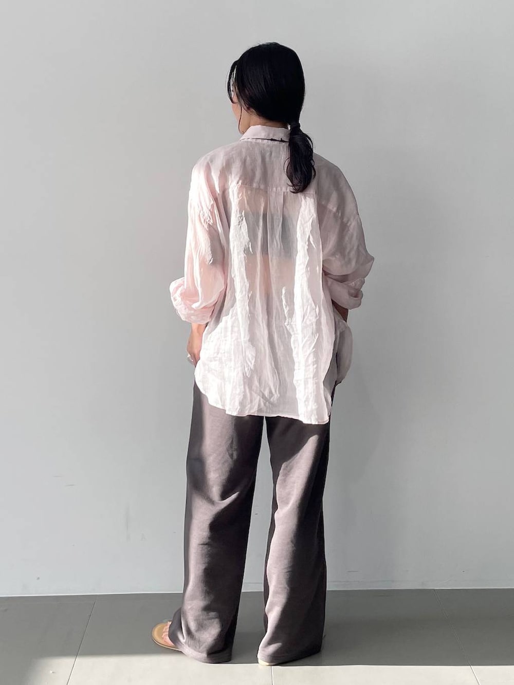 ピンク系のシャツ/ブラウス、グレー系のスウェットパンツを着用したレディースの春コーディネートの3枚目の写真