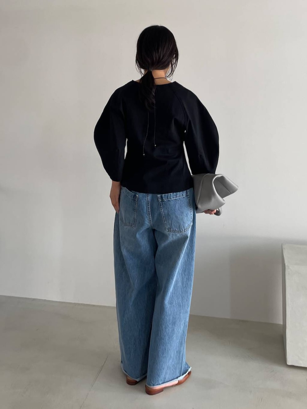 ブルー系のデニムパンツ、ブラック系のTシャツ/カットソー、グレー系のショルダーバッグを着用したレディースの春コーディネートの4枚目の写真