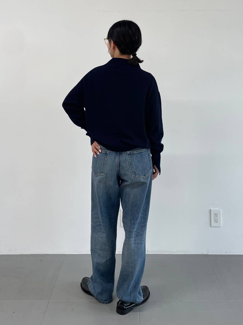 ブルー系のデニムパンツ、ブラック系のローファー、ブルー系のニット/セーターを着用したレディースの冬コーディネートの4枚目の写真