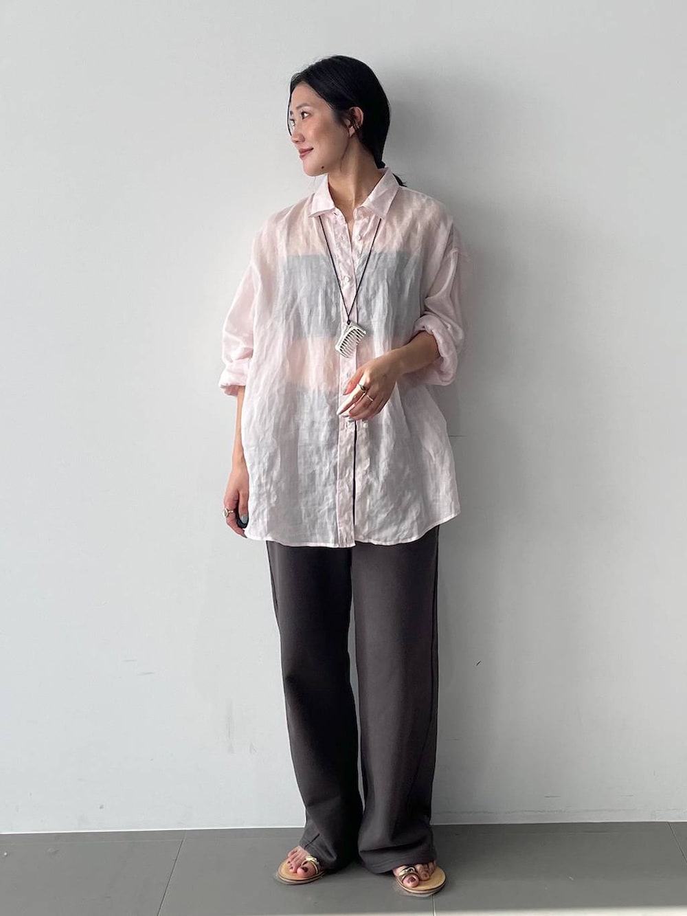 ピンク系のシャツ/ブラウス、グレー系のスウェットパンツを着用したレディースの春コーディネートの2枚目の写真