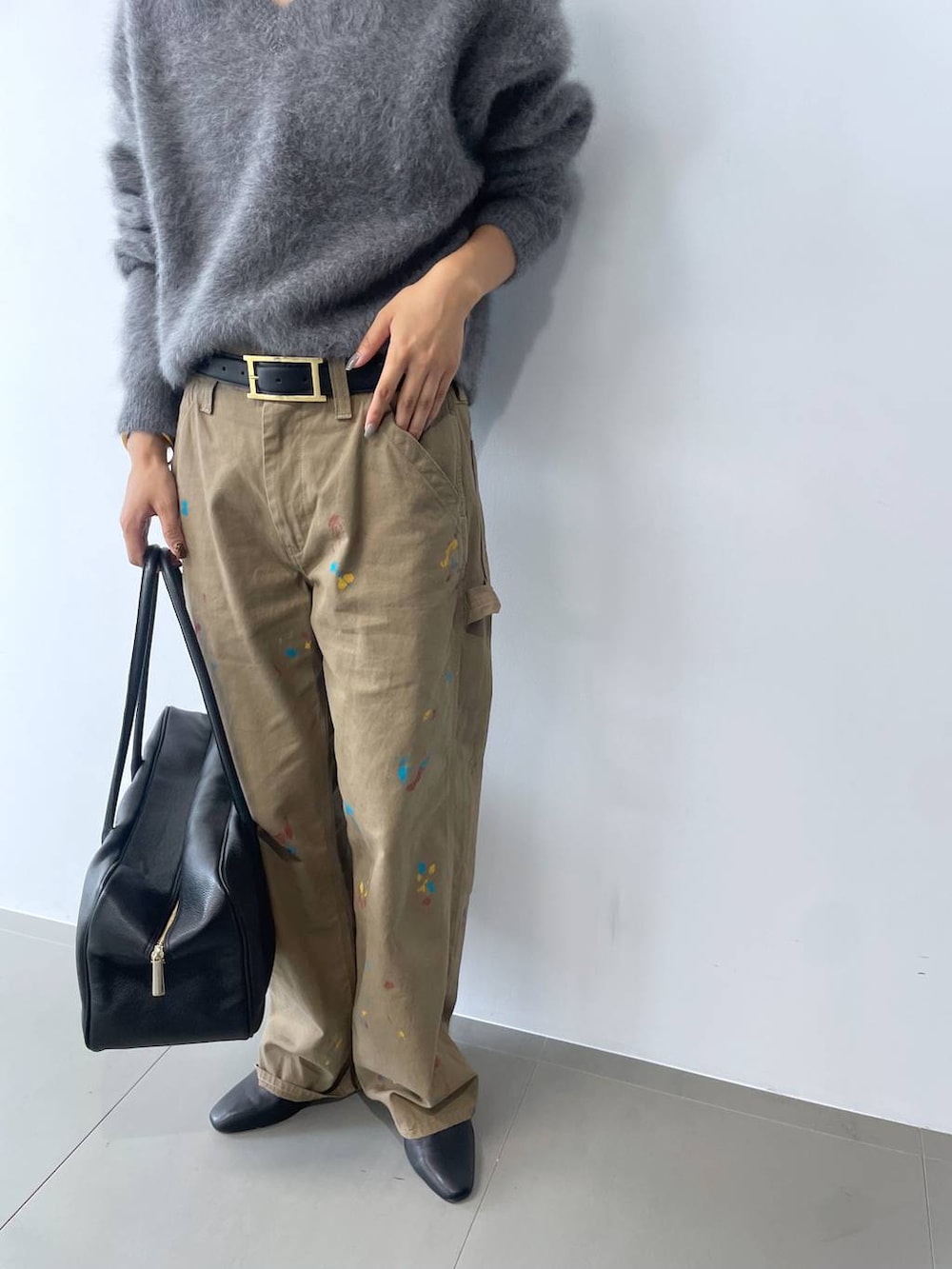 グレー系のニット/セーター、ブラック系のボストンバッグ、ブラック系のブーツを着用したレディースの秋コーディネートの6枚目の写真