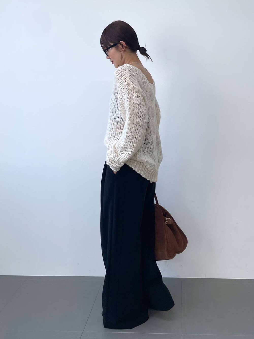 ホワイト系のニット/セーター、ブラック系のその他パンツ、ブラウン系のボストンバッグを着用したレディースの夏コーディネートの2枚目の写真