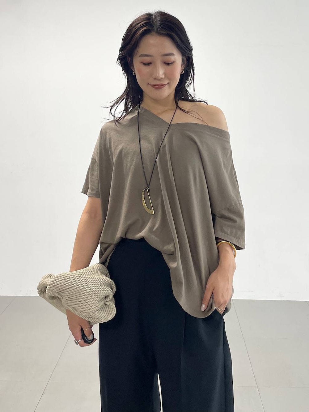 ブラック系のスラックス、グリーン系のTシャツ/カットソー、ブラック系のサンダルを着用したレディースの夏コーディネートの5枚目の写真