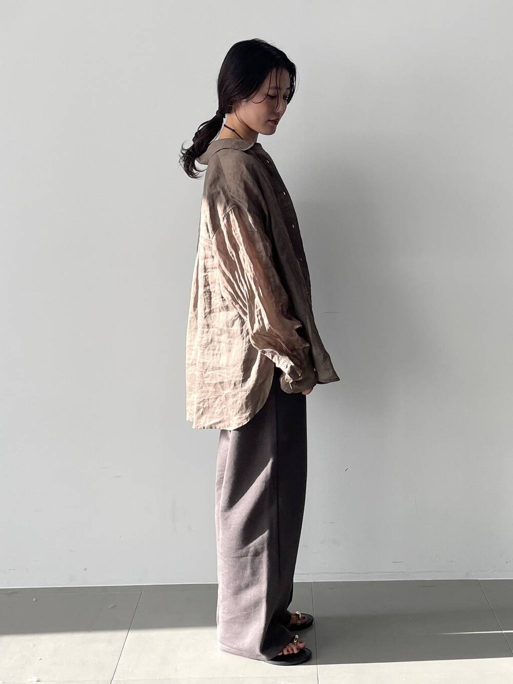 グリーン系のシャツ/ブラウス、ブラック系のキャミソール、グレー系のスウェットパンツを着用したレディースの春コーディネートの3枚目の写真