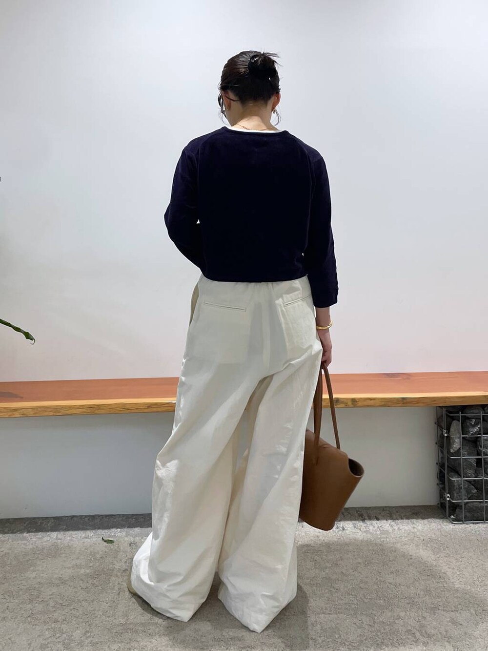 イエロー系のハンドバッグ、ホワイト系のタンクトップ、ホワイト系のその他パンツを着用したレディースの春コーディネートの4枚目の写真