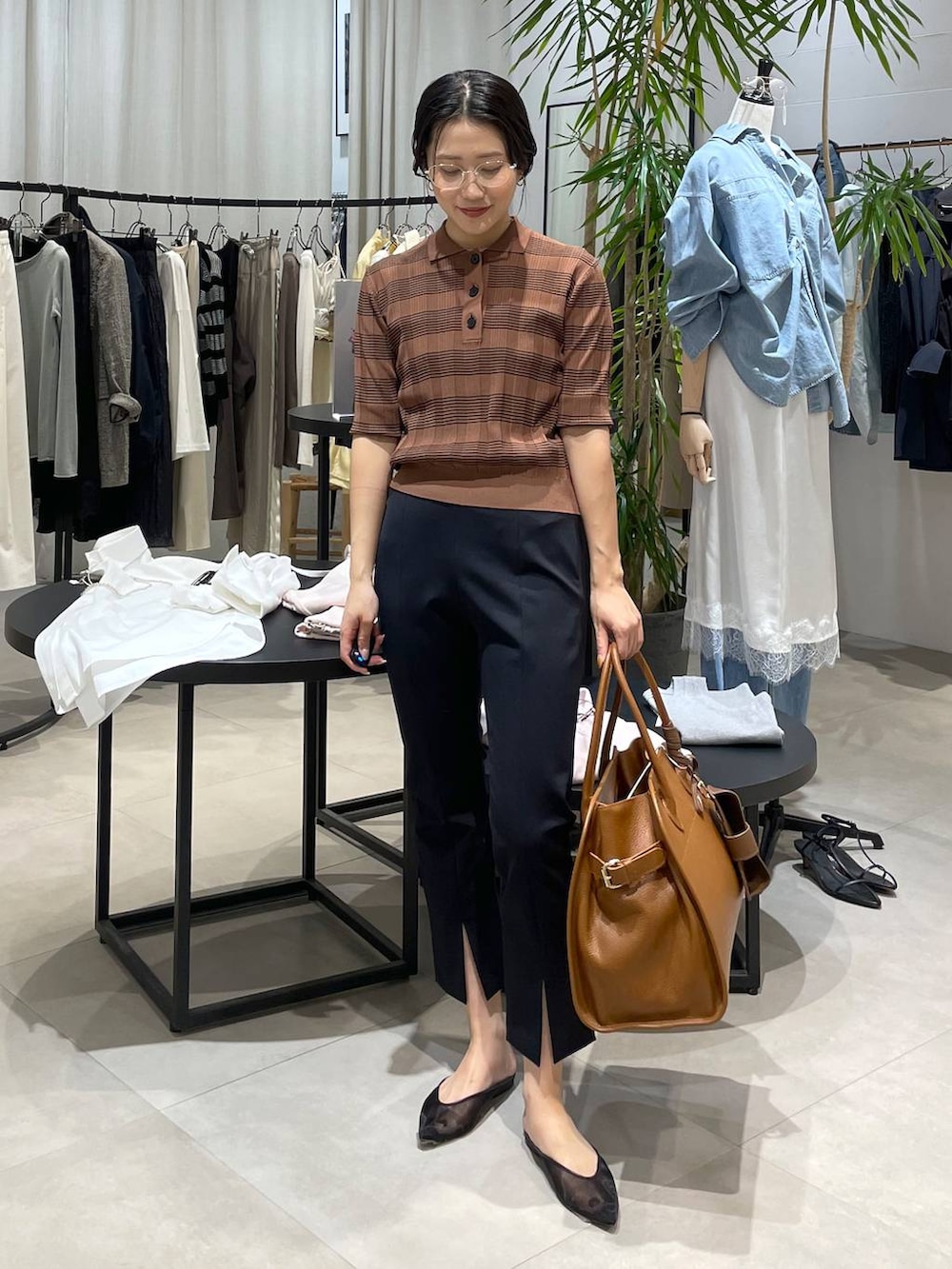 ブラック系のパンプス、ブラウン系のボストンバッグ、ブラック系のその他パンツを着用したレディースの春コーディネートの2枚目の写真