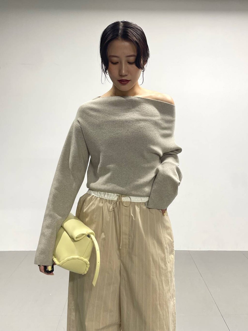 ベージュ系のパンプス、イエロー系のハンドバッグ、ベージュ系のその他パンツを着用したレディースの冬コーディネートの6枚目の写真