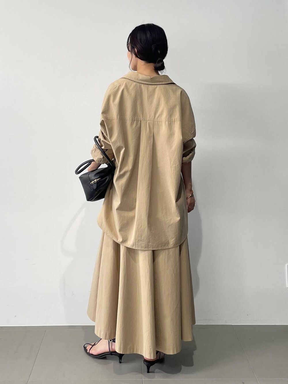 ブラック系のサンダル、ベージュ系のスカート、ベージュ系のシャツ/ブラウスを着用したレディースの春コーディネートの5枚目の写真