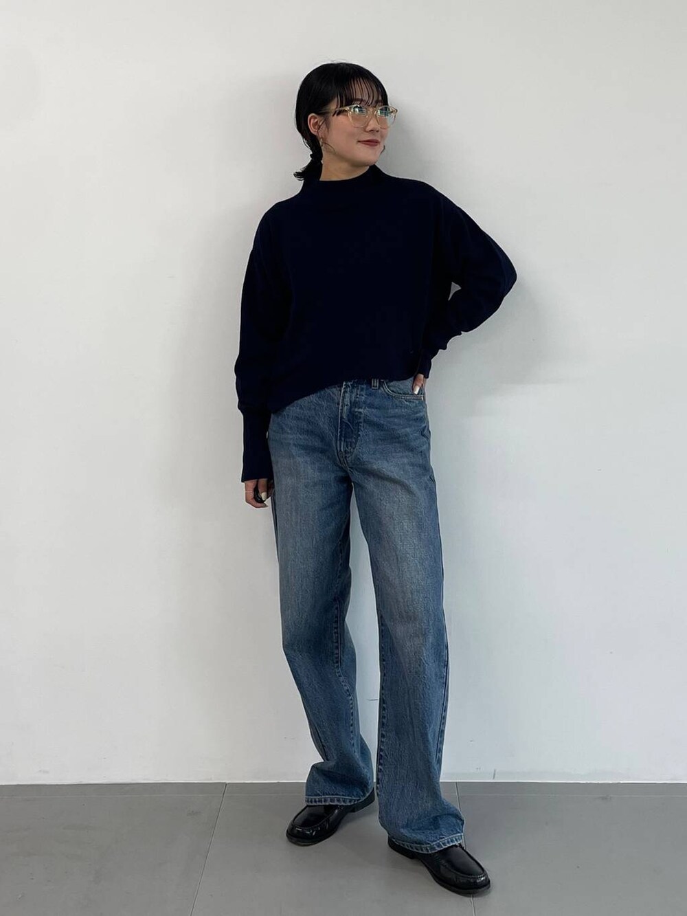 ブルー系のデニムパンツ、ブラック系のローファー、ブルー系のニット/セーターを着用したレディースの冬コーディネートの2枚目の写真