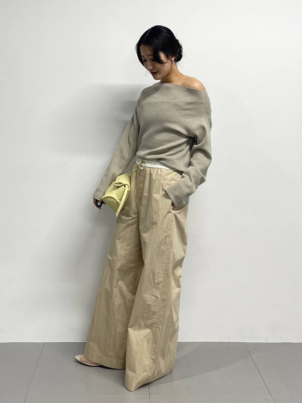 ベージュ系のパンプス、イエロー系のハンドバッグ、ベージュ系のその他パンツを着用したレディースの冬コーディネートの3枚目の写真