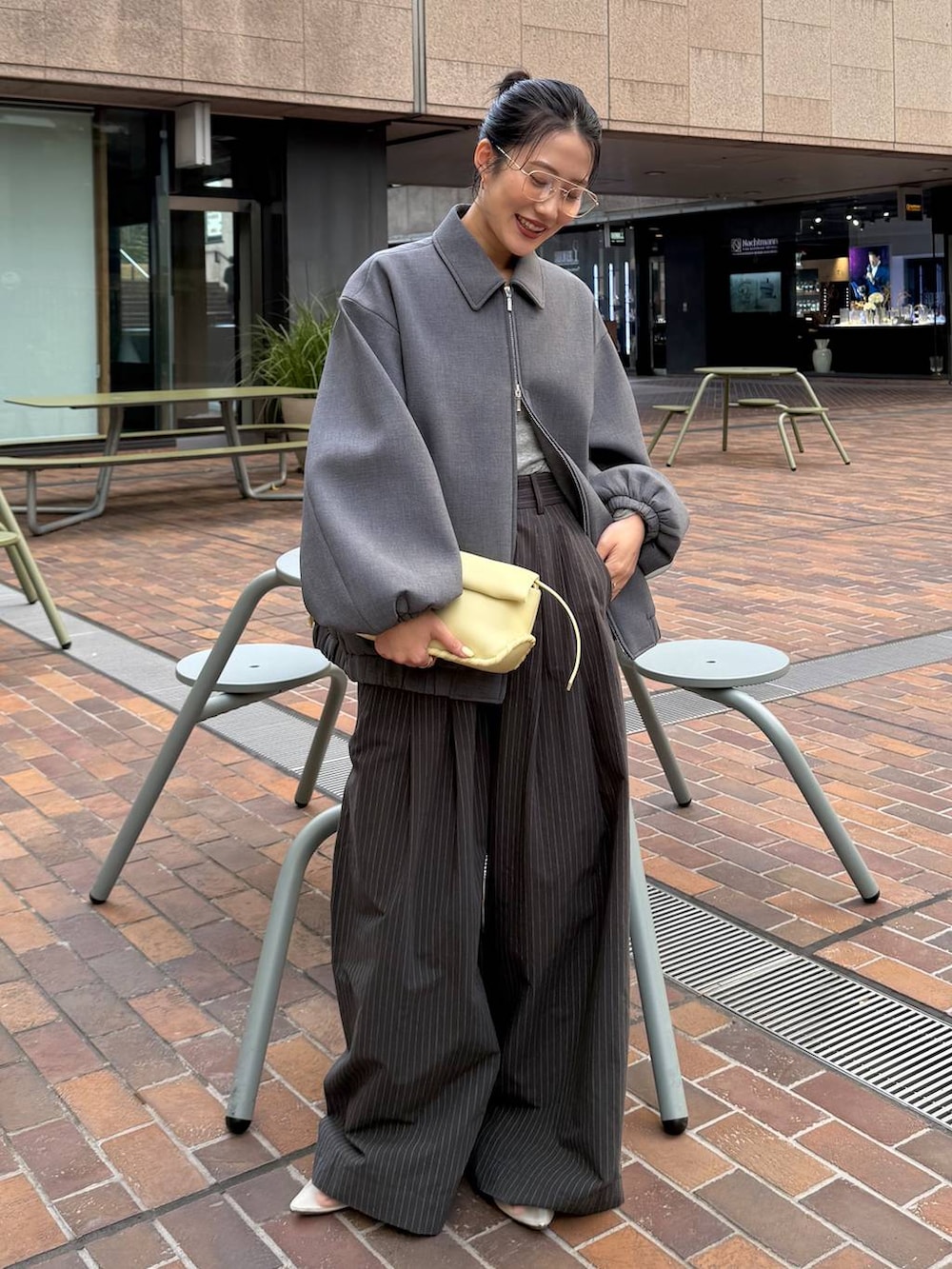 ベージュ系のパンプス、イエロー系のハンドバッグ、グレー系のTシャツ/カットソーを着用したレディースの春コーディネートの2枚目の写真