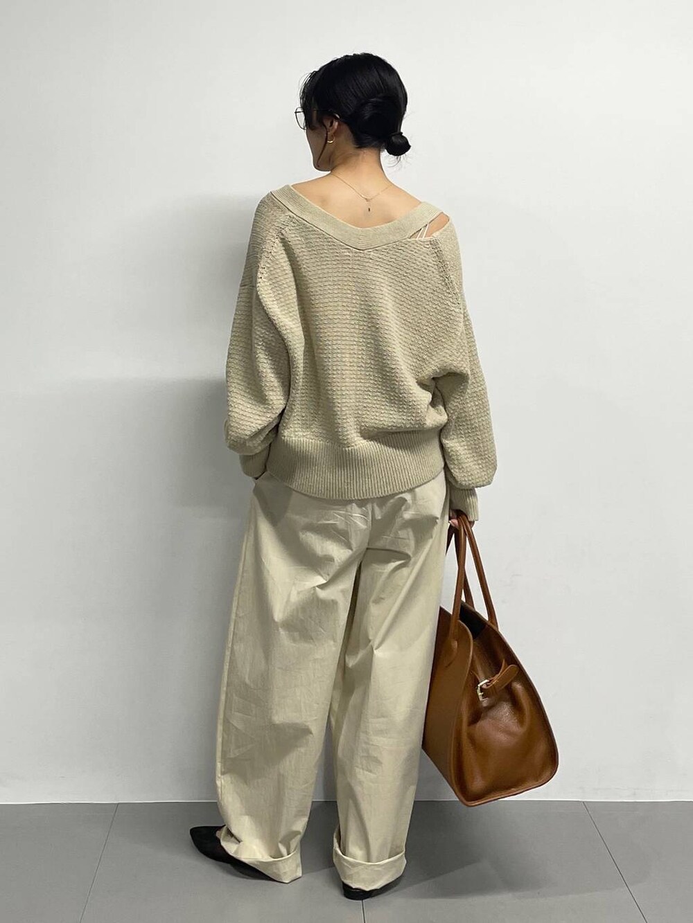 ブラック系のパンプス、ベージュ系のカーディガン/ボレロ、ブラウン系のボストンバッグを着用したレディースの春コーディネートの5枚目の写真