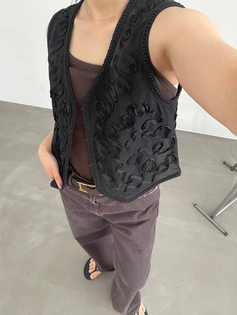 ブラック系のスリッポン、ブラウン系のタンクトップ、ブラウン系のデニムパンツを着用したレディースの夏コーディネートの8枚目の写真