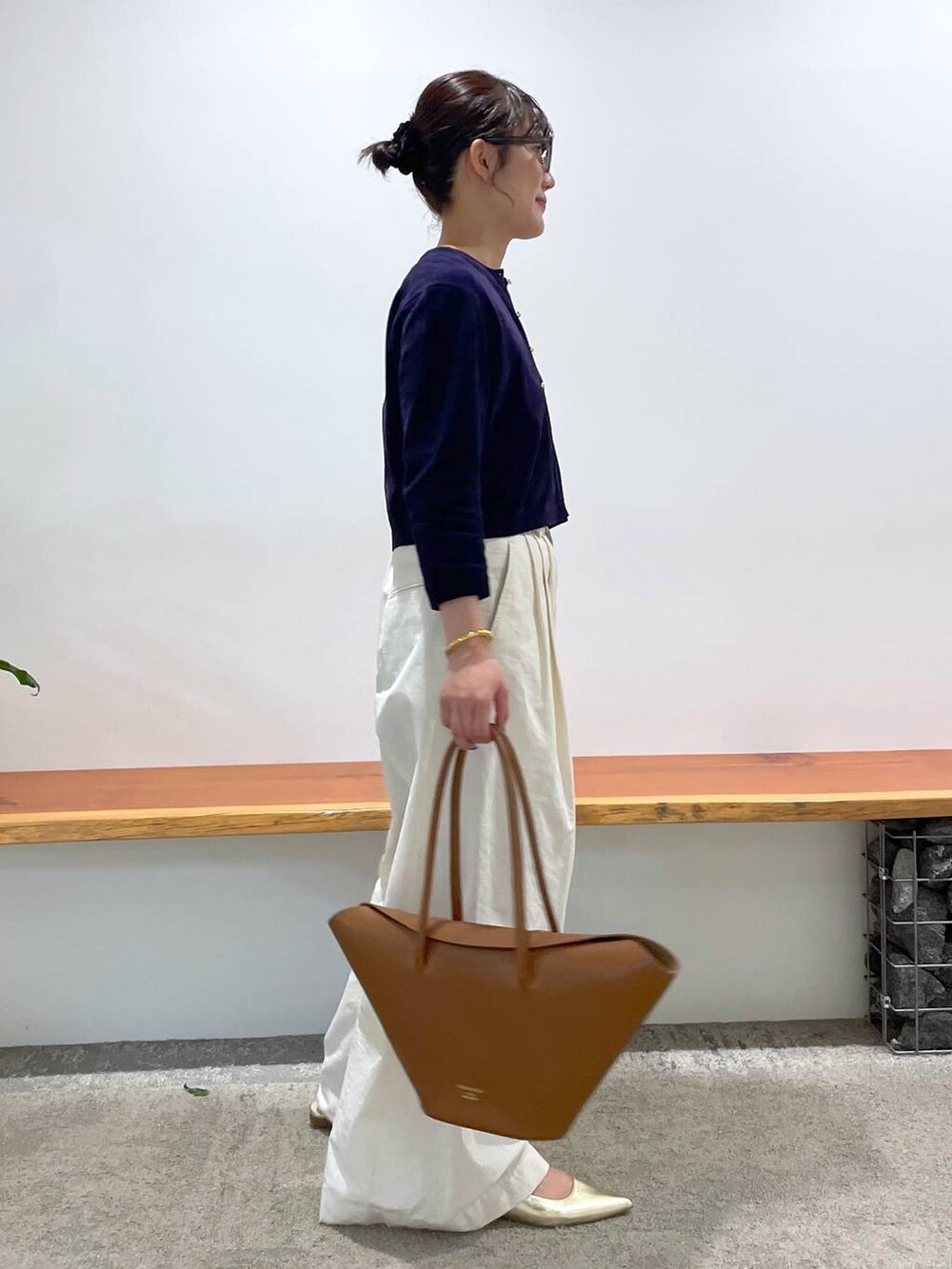 イエロー系のハンドバッグ、ホワイト系のタンクトップ、ホワイト系のその他パンツを着用したレディースの春コーディネートの3枚目の写真