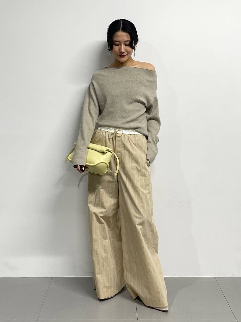 ベージュ系のパンプス、イエロー系のハンドバッグ、ベージュ系のその他パンツを着用したレディースの冬コーディネートの2枚目の写真