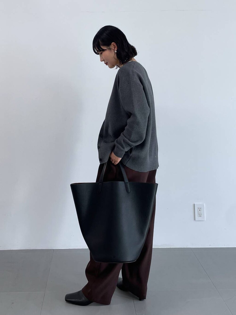 ブラック系のトートバッグ、ブラウン系のその他パンツ、グレー系のカーディガン/ボレロを着用したレディースの冬コーディネートの4枚目の写真