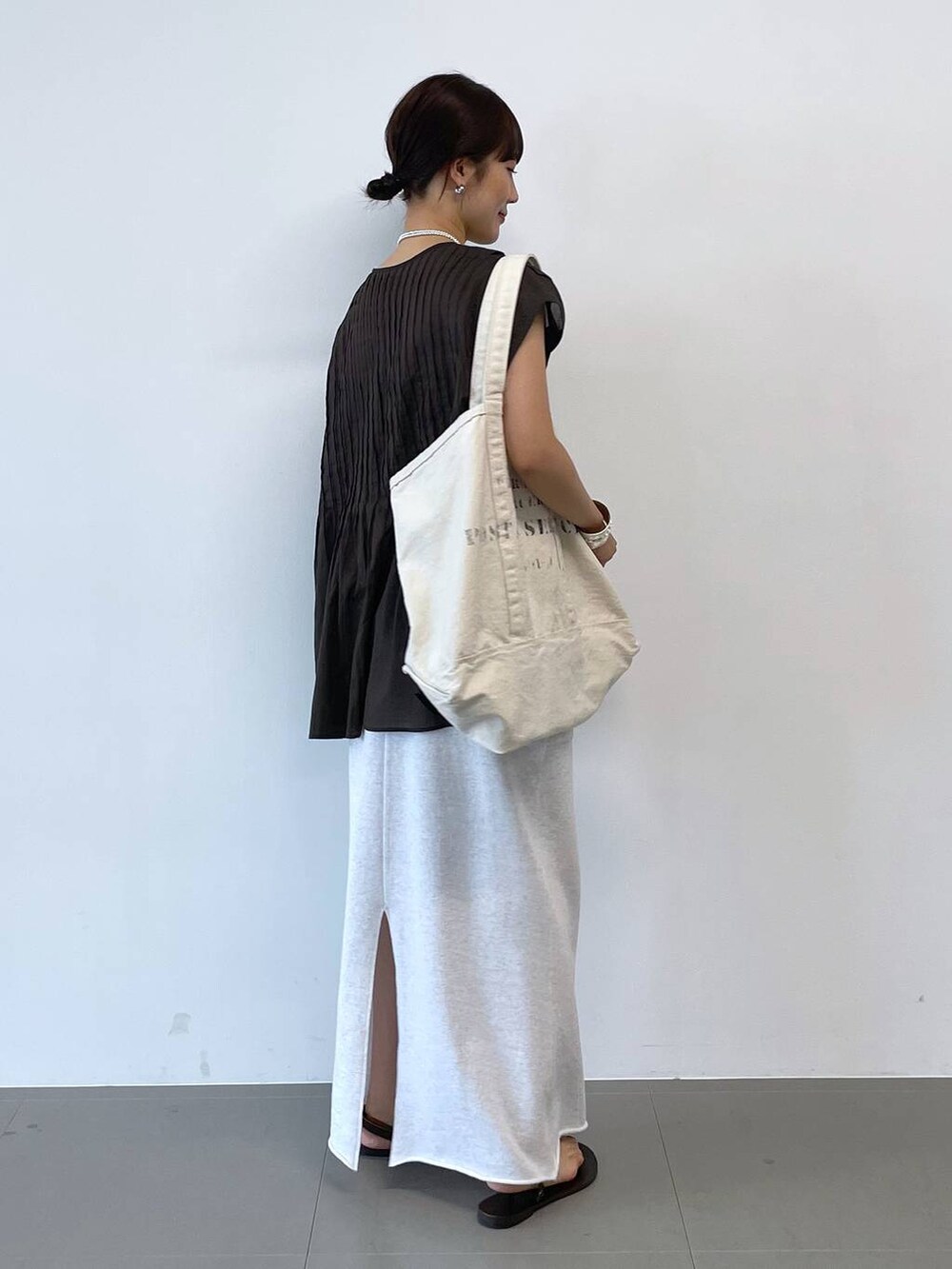 ブラウン系のサンダル、グレー系のスカート、ブラック系のタンクトップを着用したレディースの夏コーディネートの2枚目の写真